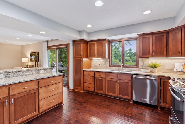 3291 Hillsboro Ave S, Saint Louis Park, MN 55426 - kitchen with stainless steel appliances, brown cabinets, light stone countertops, dark wood finished floors, and backsplash
