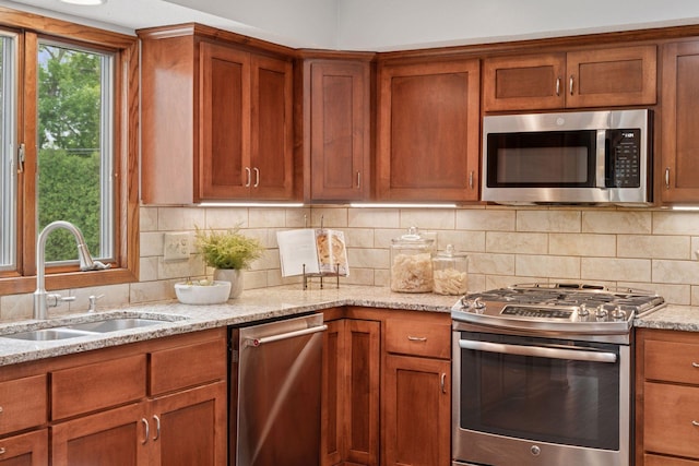 3291 Hillsboro Ave S, Saint Louis Park, MN 55426 - kitchen with stainless steel appliances, brown cabinets, light stone counters, and decorative backsplash