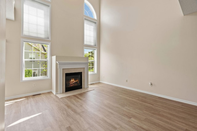 1353 White Oak Dr, Chaska, MN 55318 - unfurnished living room with healthy amount of natural light, wood finished floors, a fireplace, and a high ceiling