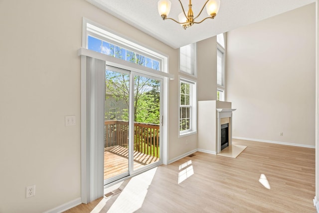 1353 White Oak Dr, Chaska, MN 55318 - doorway to outside with a chandelier, baseboards, light wood finished floors, and a fireplace with flush hearth