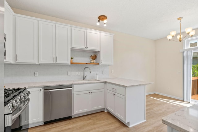 1353 White Oak Dr, Chaska, MN 55318 - kitchen featuring stainless steel appliances, a sink, a peninsula, tasteful backsplash, and light wood-style flooring