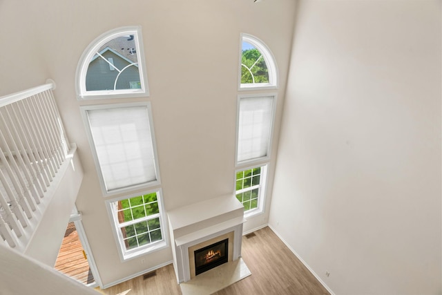 1353 White Oak Dr, Chaska, MN 55318 - unfurnished living room with a high ceiling, baseboards, a fireplace with flush hearth, and wood finished floors