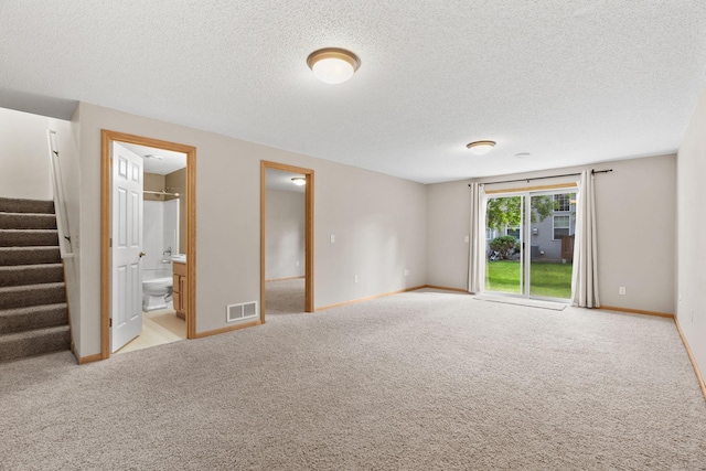 1353 White Oak Dr, Chaska, MN 55318 - unfurnished bedroom featuring access to outside, a textured ceiling, carpet floors, baseboards, and connected bathroom