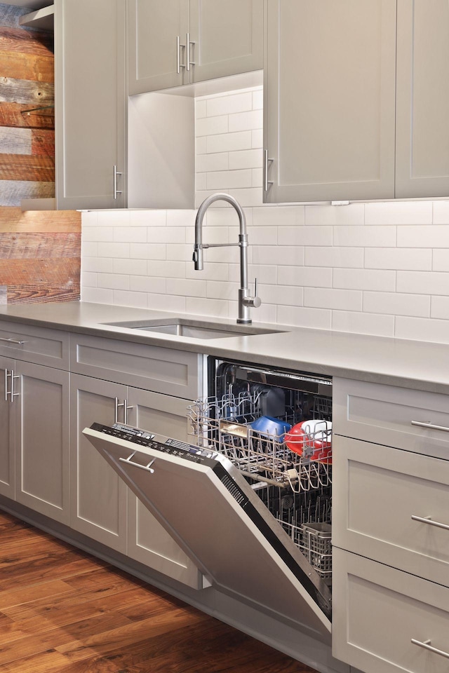 kitchen with a sink, gray cabinetry, and dark wood finished floors