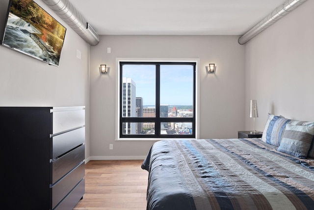 bedroom with light wood-type flooring and baseboards