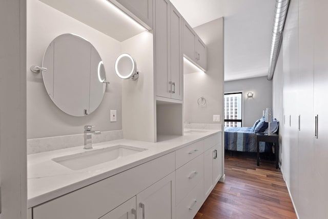 ensuite bathroom featuring wood finished floors and double vanity