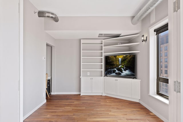 unfurnished living room with light wood-style flooring and baseboards