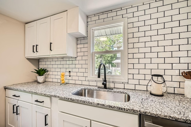 6670 Hopi Rd, Chanhassen, MN 55317 - kitchen with a sink, tasteful backsplash, dishwasher, white cabinetry, and light stone counters