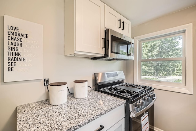 6670 Hopi Rd, Chanhassen, MN 55317 - kitchen featuring appliances with stainless steel finishes, light stone counters, and white cabinets