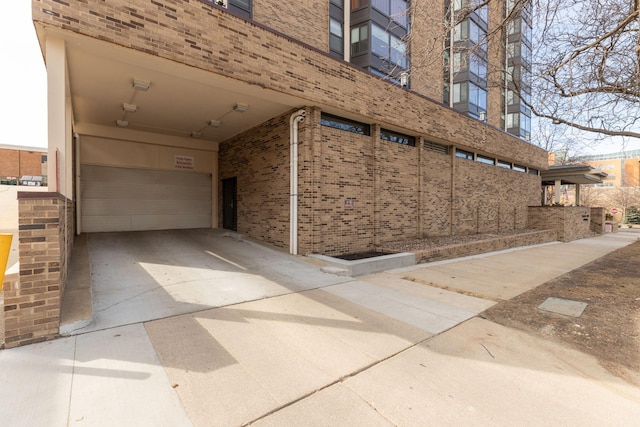 207 5th Ave SW Unit 407, Rochester, MN 55902 - view of home's exterior featuring brick siding, a carport, driveway, and a garage