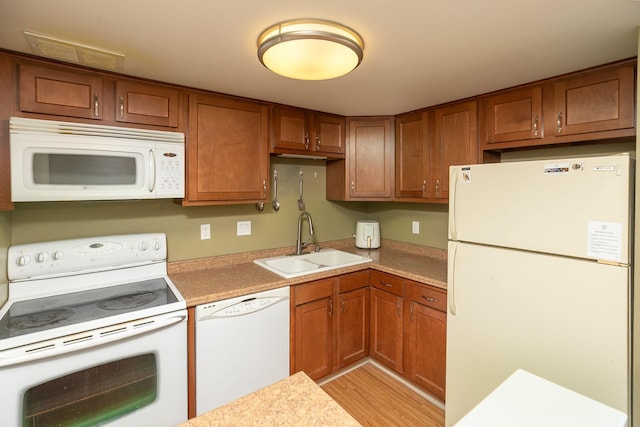 207 5th Ave SW Unit 407, Rochester, MN 55902 - kitchen featuring white appliances, a sink, brown cabinets, light wood-style flooring, and light countertops