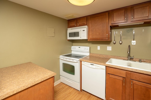 207 5th Ave SW Unit 407, Rochester, MN 55902 - kitchen with white appliances, a sink, light wood-style flooring, brown cabinets, and light countertops