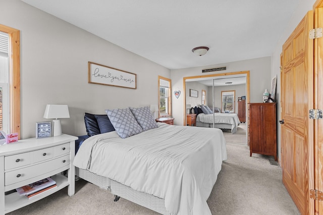 bedroom with light carpet and a closet