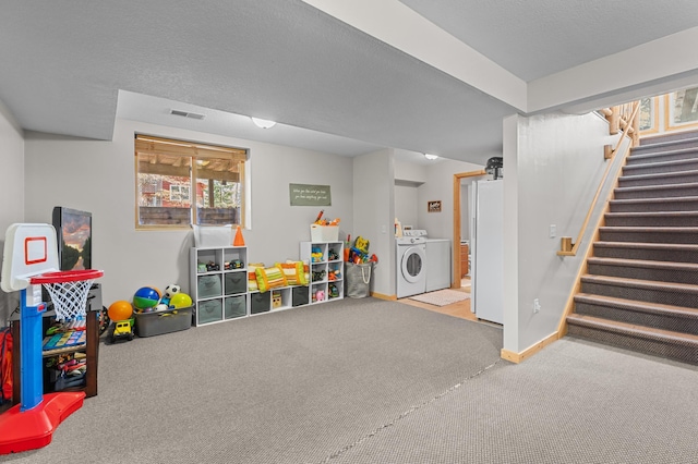 recreation room with carpet floors, separate washer and dryer, and baseboards
