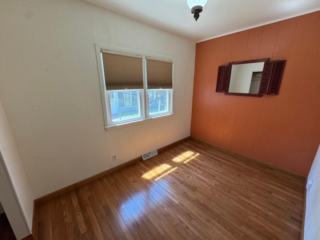 753 Mark St, Winona, MN 55987 - empty room featuring hardwood / wood-style flooring, ornamental molding, and wood walls