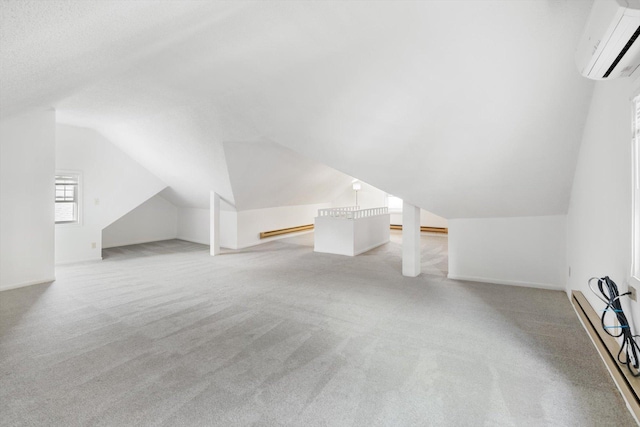 bonus room featuring baseboard heating, a wall unit AC, light carpet, lofted ceiling, and baseboards