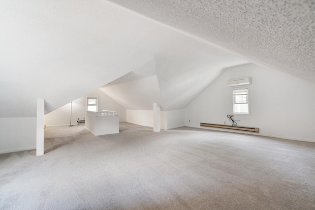 bonus room with a baseboard radiator, light carpet, a wall mounted air conditioner, lofted ceiling, and a textured ceiling