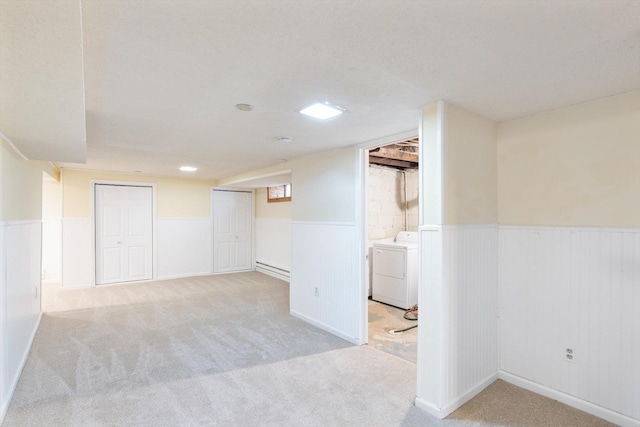 finished below grade area featuring washer / clothes dryer, a wainscoted wall, and carpet