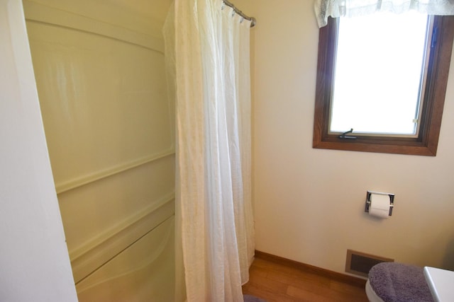 13946 151st St NE, Thief River Falls, MN 56701 - full bathroom with wood finished floors, toilet, and a shower with curtain