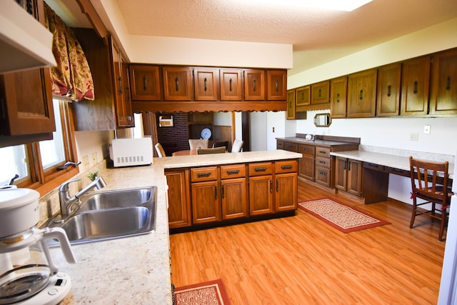 13946 151st St NE, Thief River Falls, MN 56701 - kitchen with white microwave, a sink, light countertops, light wood-style floors, and a peninsula