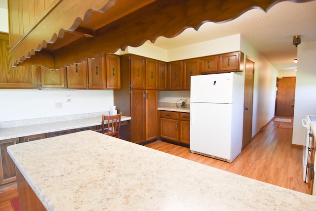 13946 151st St NE, Thief River Falls, MN 56701 - kitchen with freestanding refrigerator, light countertops, light wood-style floors, and brown cabinetry