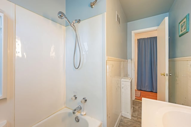 1202 Webster St, Fairmont, MN 56031 - full bath with shower / tub combination, tile walls, and a wainscoted wall