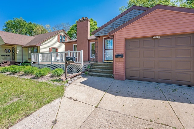 1202 Webster St, Fairmont, MN 56031 - view of front of house featuring concrete driveway, a chimney, an attached garage, and a wooden deck