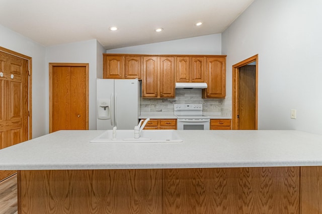 202 6th St NE, Montgomery, MN 56069 - kitchen featuring white appliances, a sink, under cabinet range hood, lofted ceiling, and light countertops