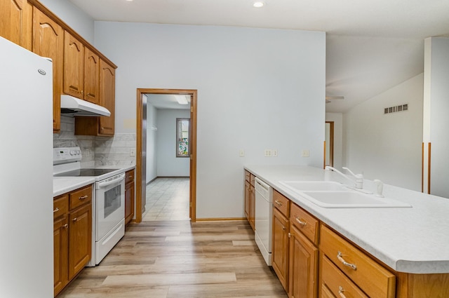 202 6th St NE, Montgomery, MN 56069 - kitchen with white appliances, under cabinet range hood, a sink, a peninsula, and decorative backsplash
