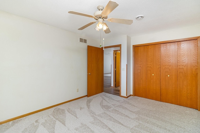 202 6th St NE, Montgomery, MN 56069 - unfurnished bedroom featuring carpet flooring, baseboards, a closet, and a ceiling fan