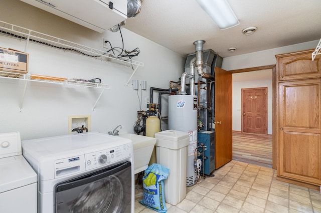 202 6th St NE, Montgomery, MN 56069 - laundry area featuring washer and dryer, water heater, and cabinet space