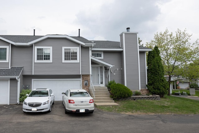 view of front of property with driveway, a garage, a shingled roof, and a chimney