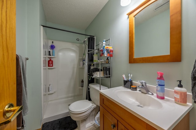 full bathroom featuring a stall shower, vanity, a textured ceiling, and toilet