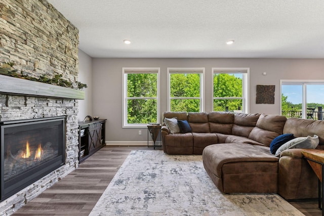 9222 Bridle Way, Victoria, MN 55386 - living area featuring a fireplace, wood finished floors, a textured ceiling, recessed lighting, and baseboards