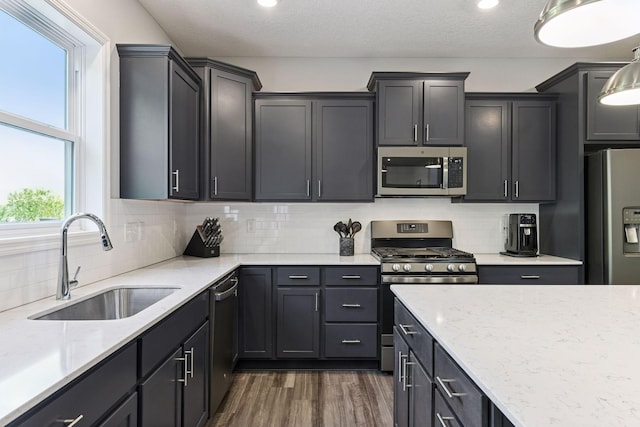 9222 Bridle Way, Victoria, MN 55386 - kitchen featuring stainless steel appliances, a sink, dark wood-style floors, light stone countertops, and decorative backsplash