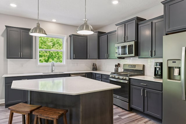 9222 Bridle Way, Victoria, MN 55386 - kitchen with stainless steel appliances, a sink, a kitchen bar, light wood-type flooring, and recessed lighting