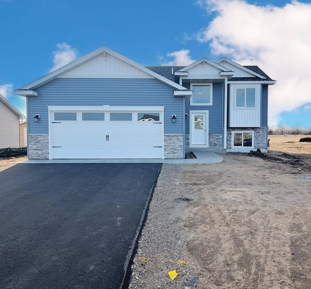 1311 Jasmine Ln NE, Saint Joseph, MN 56374 - view of front of home with stone siding, asphalt driveway, and an attached garage