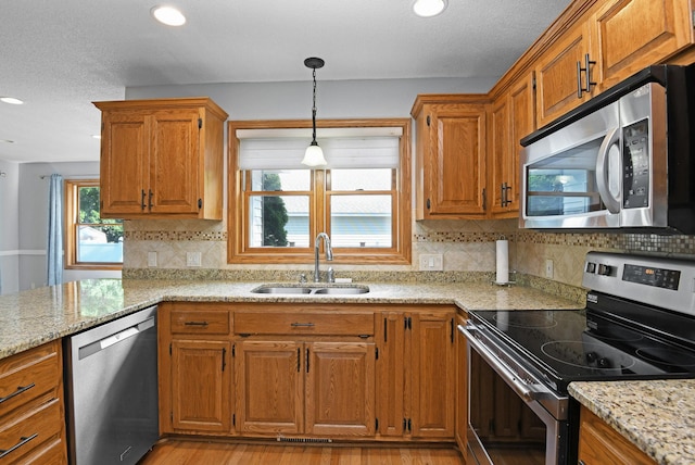 2403 Goettens Way, Saint Cloud, MN 56301 - kitchen with appliances with stainless steel finishes, a sink, pendant lighting, brown cabinetry, and recessed lighting