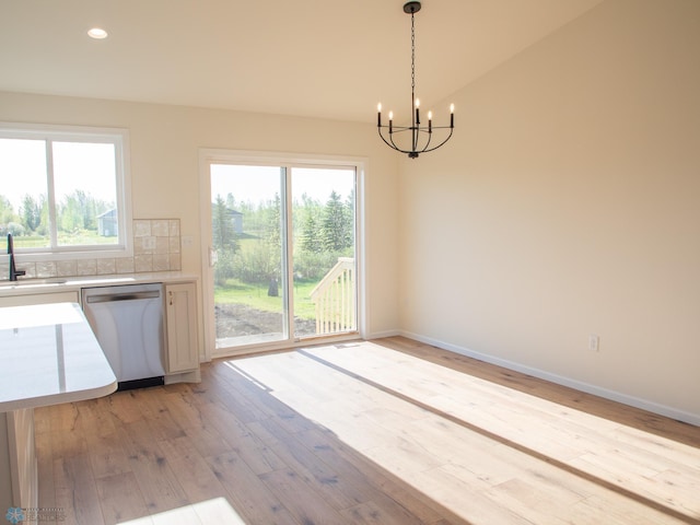 10302 Burgundy Dr, Horace, ND 58047 - kitchen with dishwasher, a chandelier, light wood-type flooring, light countertops, and baseboards