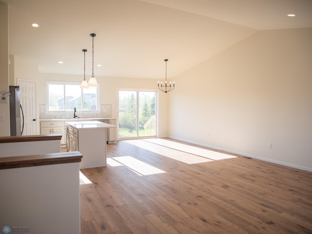 10302 Burgundy Dr, Horace, ND 58047 - empty room with light wood-style floors, a chandelier, lofted ceiling, recessed lighting, and baseboards