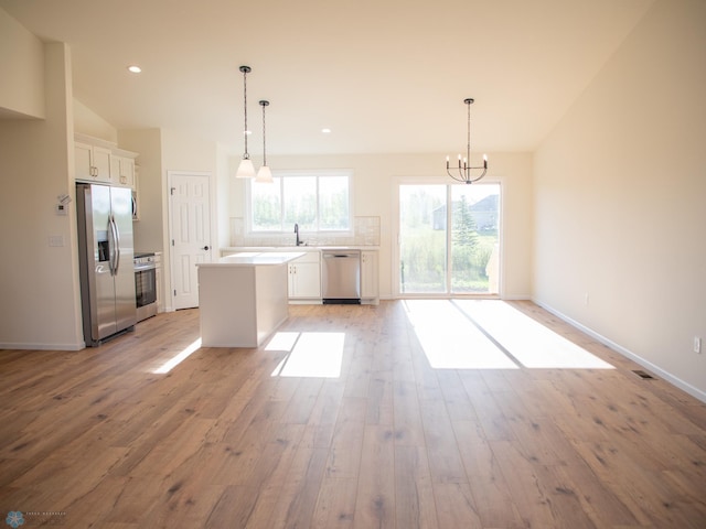 10302 Burgundy Dr, Horace, ND 58047 - kitchen featuring stainless steel appliances, light wood finished floors, white cabinetry, a kitchen island, and a chandelier