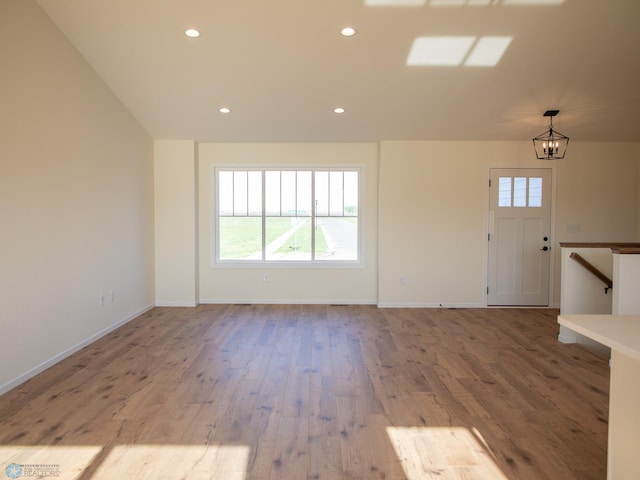 10302 Burgundy Dr, Horace, ND 58047 - unfurnished living room featuring plenty of natural light, wood finished floors, a chandelier, baseboards, and recessed lighting