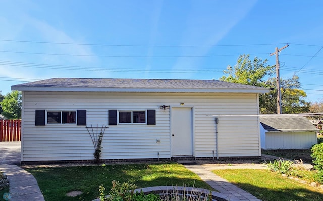 rear view of house featuring a yard and an outbuilding