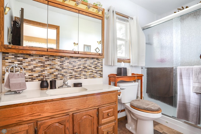 bathroom featuring tasteful backsplash, toilet, a stall shower, and vanity