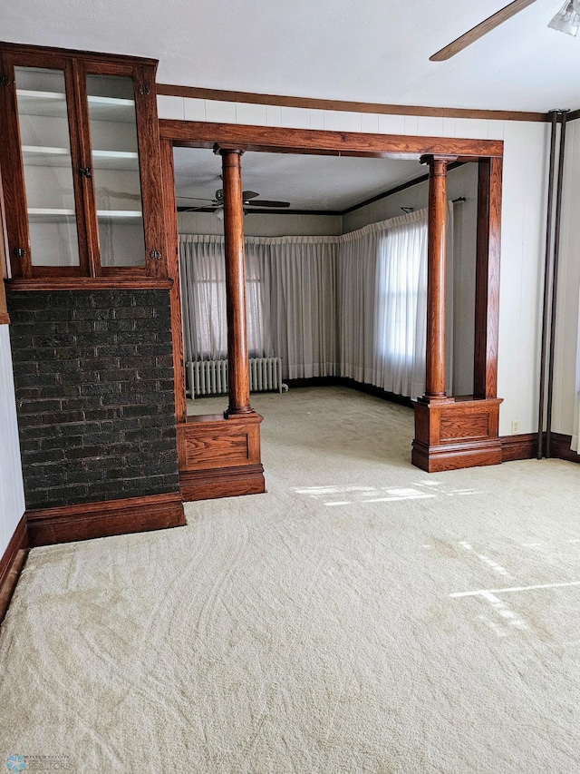 unfurnished living room featuring radiator heating unit, carpet, ceiling fan, and baseboards