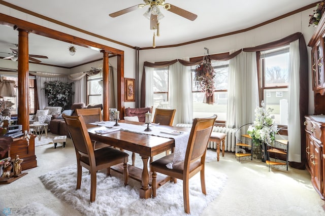 dining room featuring ceiling fan, ornamental molding, light colored carpet, ornate columns, and radiator