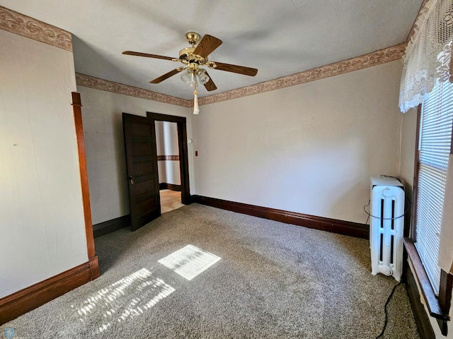carpeted spare room with radiator heating unit, ceiling fan, and baseboards