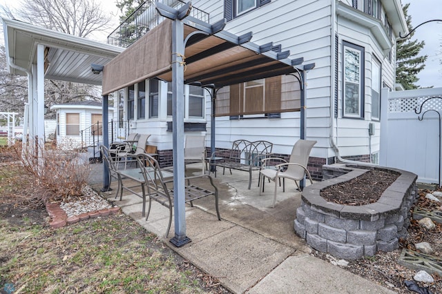 view of patio / terrace with a balcony and an outdoor fire pit