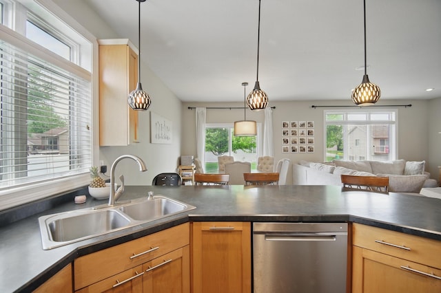 kitchen featuring stainless steel dishwasher, open floor plan, dark countertops, a sink, and hanging light fixtures