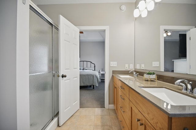 ensuite bathroom with a shower stall, tile patterned flooring, and double vanity